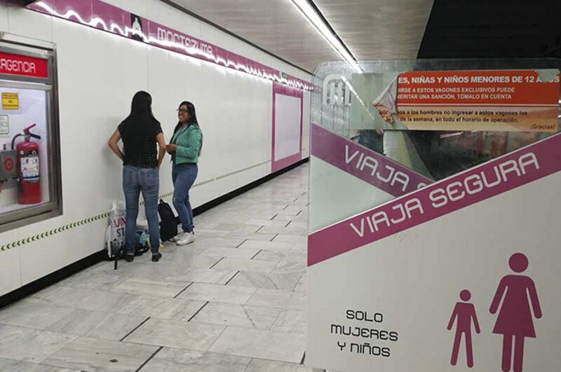 Mujeres y niños esperan en el anden del metro