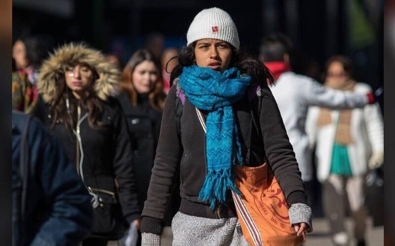 Mujer abrigada caminando por la calle en invierno