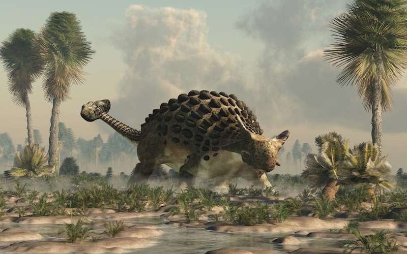 Un dinosaurio anquilosaurio camina por un paisaje prehistórico