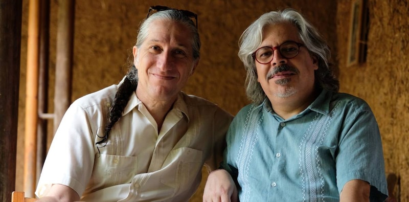 Dos hombres sonríen a la cámara.