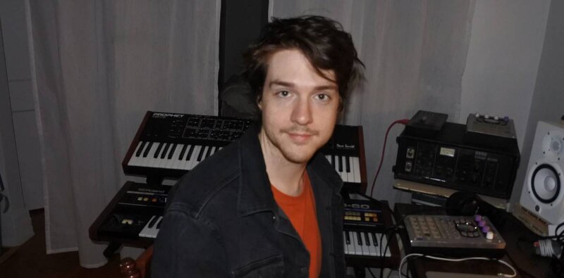 Un joven músico toca un sintetizador.