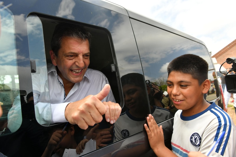 El candidato presidencial chileno Gabriel Boric saluda a un niño durante su campaña electoral.