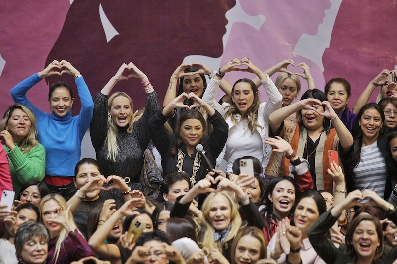 Mujeres haciendo corazones con las manos