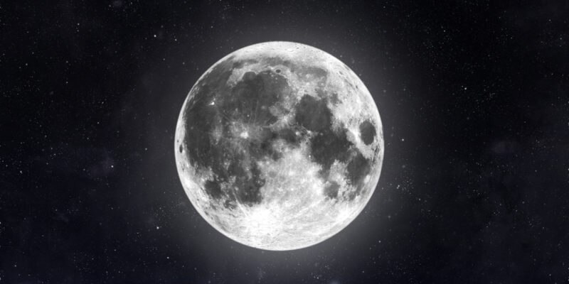 La luna llena se eleva sobre el horizonte nocturno