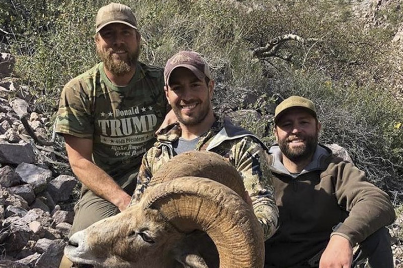 Tres cazadores sonríen junto a un borrego cimarrón muerto.