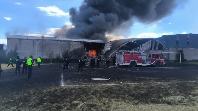 Bomberos y policías acudieron a atender el incendio generado en la bodega al lado de un campo de futbol tras la caída de la aeronave.