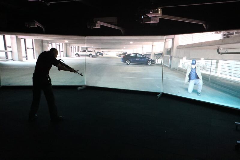 Un policía apunta con su arma a un sospechoso en un aparcamiento