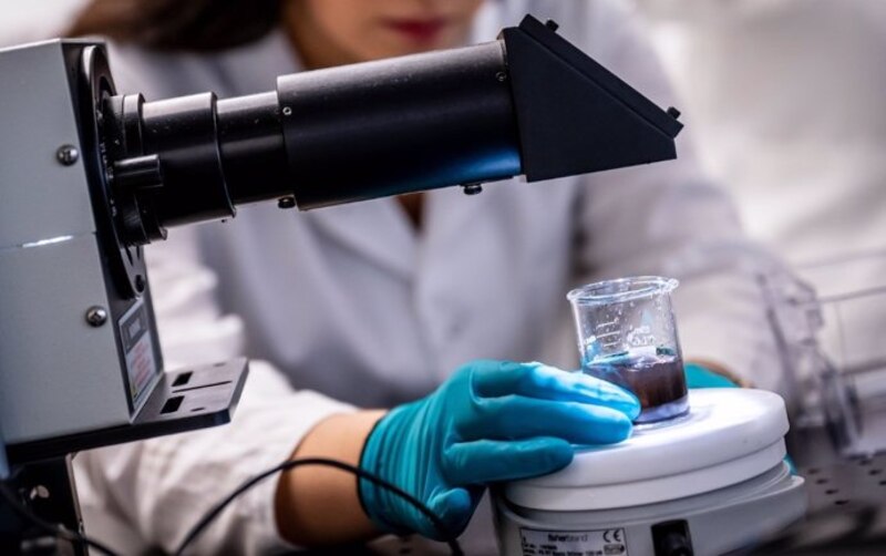 Científica examinando una muestra en un laboratorio