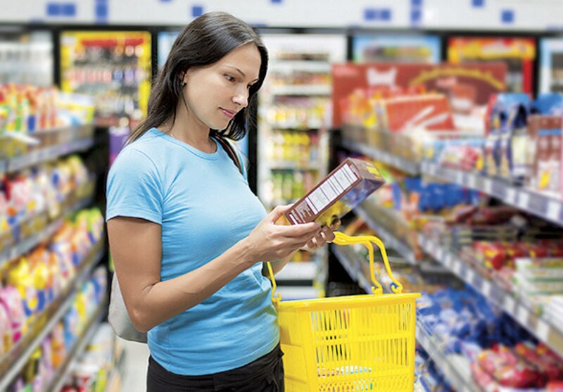 Mujer leyendo la etiqueta de un producto en el supermercado