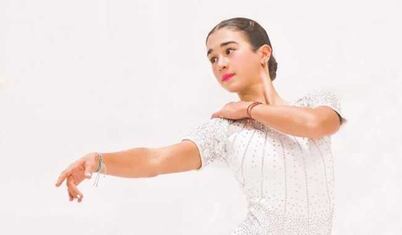 Joven patinadora artística realizando una pirueta sobre hielo