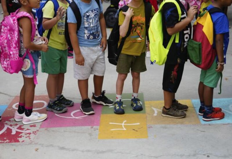 Niños de primaria haciendo fila en el patio del colegio