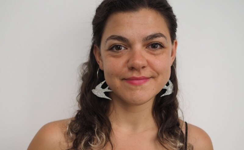 Mujer joven con aretes de pájaros