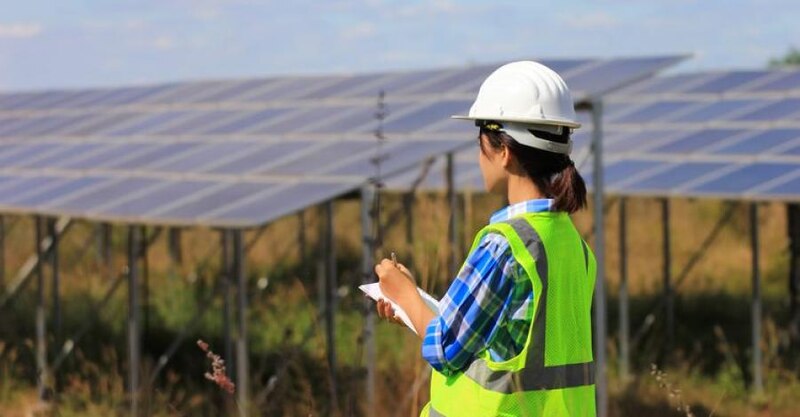 Mujer ingeniera en un campo de paneles solares