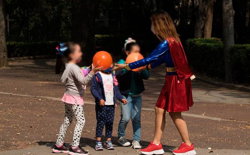 Mujer disfrazada de superheroína juega con niños en un parque