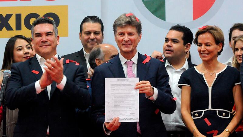 El presidente electo de México, Andrés Manuel López Obrador, muestra el documento que lo acredita como tal.