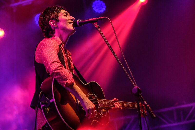 Cantante tocando la guitarra en un concierto