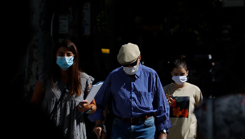 Personas con mascarillas caminando por la calle