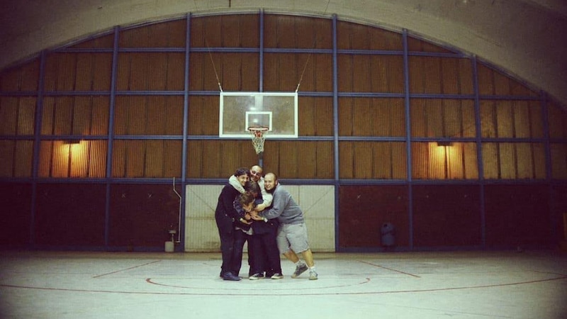 Un grupo de amigos jugando baloncesto en un gimnasio