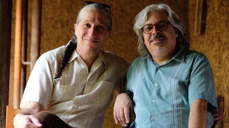 Dos hombres sonríen a la cámara.