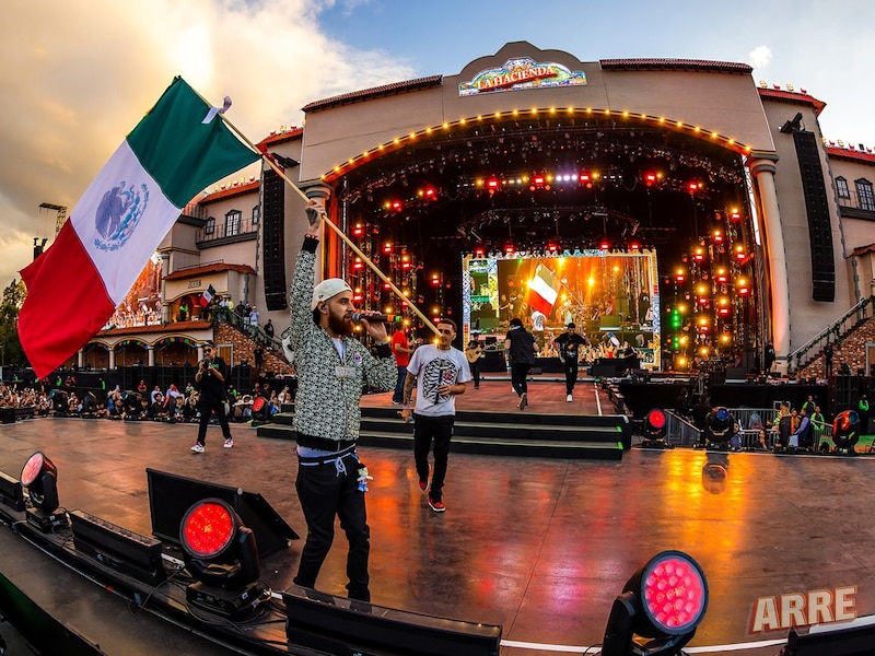 ¡Viva México! Karol G ondeando la bandera de México en el escenario.