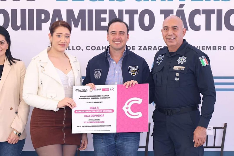 Manolo Jiménez entregando beca a policía e hija