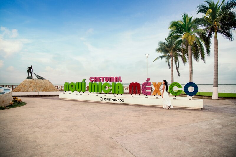 Mujer caminando frente al letrero de Chetumal, Quintana Roo, México