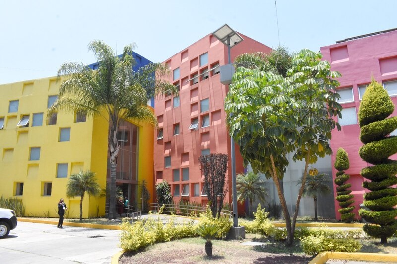 Edificio de apartamentos con fachada de color amarillo, azul y rosa