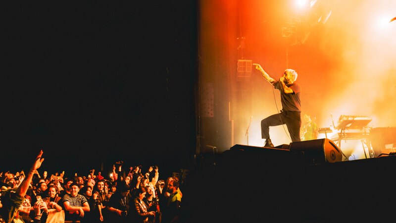 Artista de música rock alternativo se presenta en vivo ante una multitud