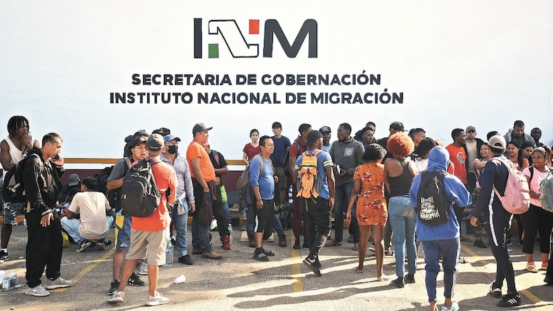 Migrantes esperan fuera de las oficinas del Instituto Nacional de Migración en espera de regularizar su situación migratoria.