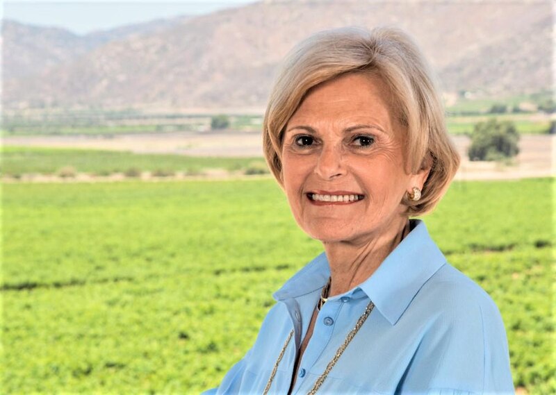 Mujer mayor sonriendo en un campo verde