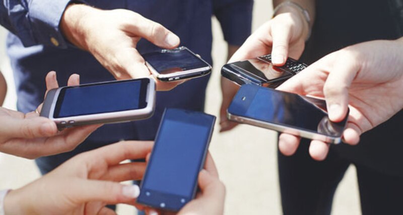 Jóvenes usando sus teléfonos móviles