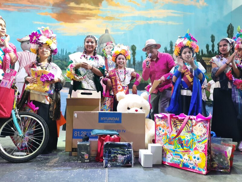 Niñas reciben regalos en un concurso de belleza infantil.