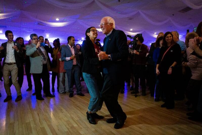 Bernie Sanders bailando con una joven en un mitin político