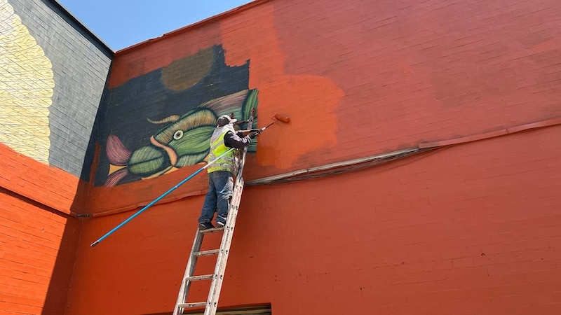 Pintor trabajando en un mural