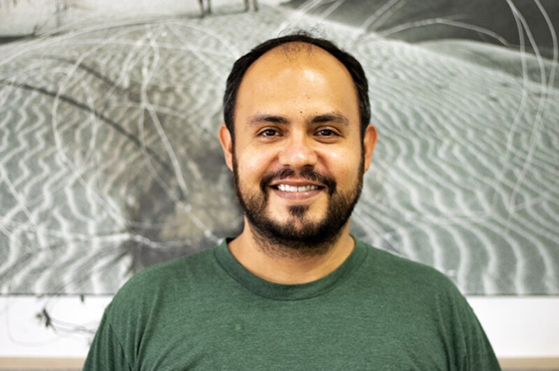 Retrato de un hombre sonriente con barba y cabello negro