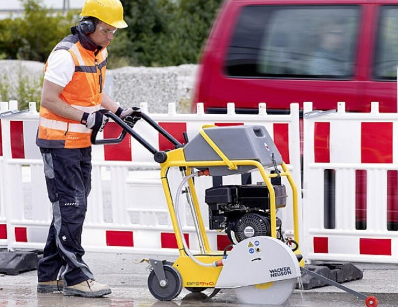 Trabajador de la construcción cortando asfalto con una máquina