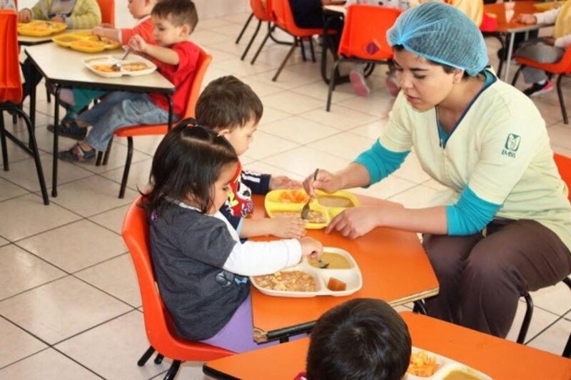 Niños comiendo en el comedor de una escuela