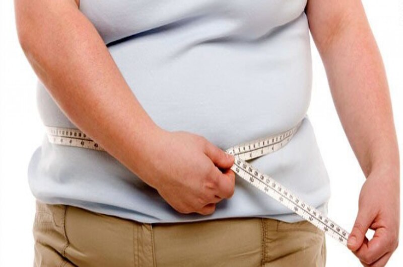 Mujer obesa midiéndose el contorno de la cintura
