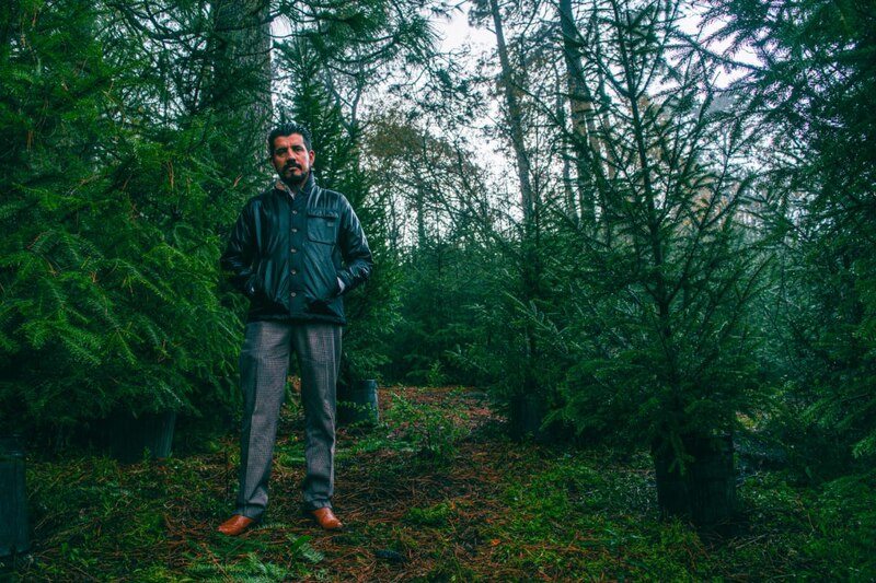 Un hombre en un bosque de árboles de Navidad