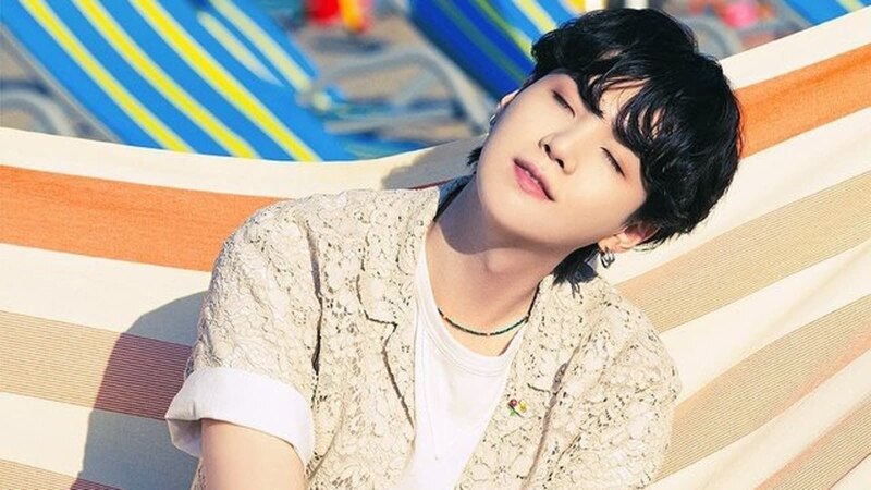 Suga de BTS tomando el sol en una hamaca