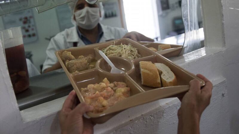 Un preso recibe su comida en una bandeja