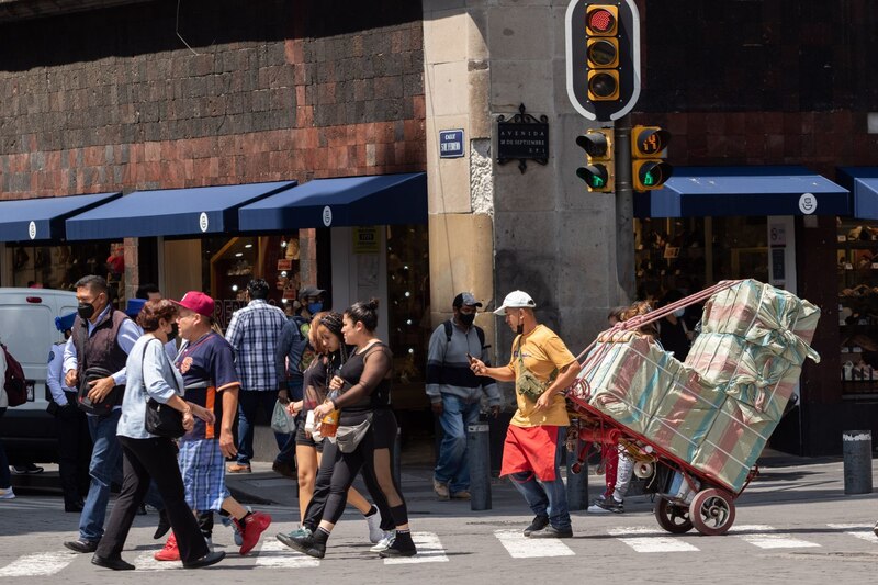 Un vendedor ambulante cruza la calle en el Centro Histórico de la Ciudad de México