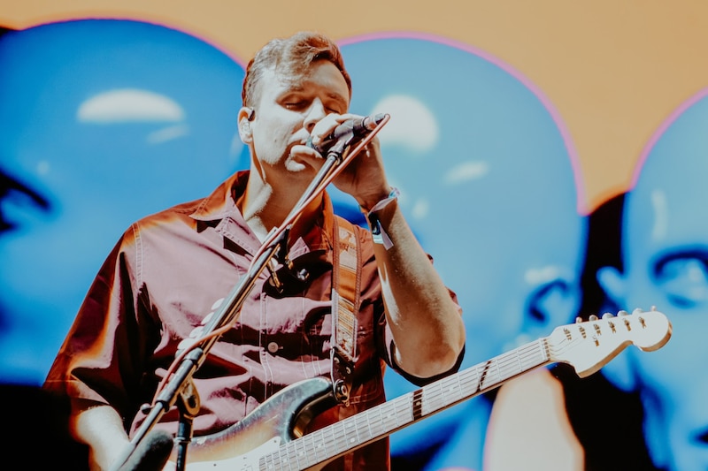 Cantante tocando la guitarra en un concierto