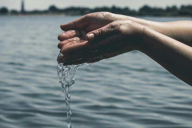 Manos sosteniendo un vaso de agua