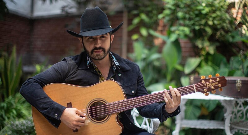 El cantante de música regional mexicana, Christian Nodal, tocando la guitarra.
