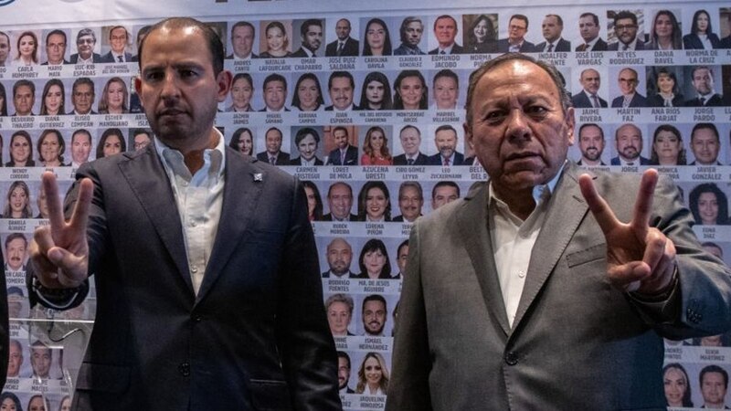 Title: Políticos mexicanos haciendo la señal de la paz con los dedos.