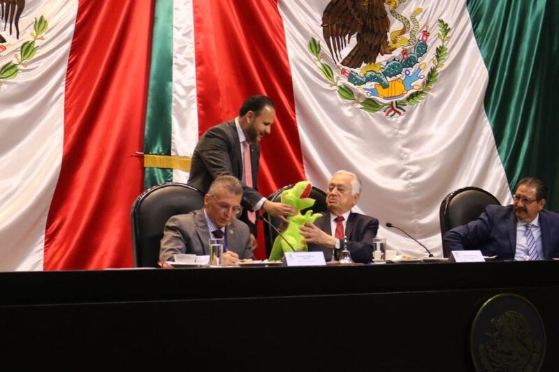 Políticos mexicanos con un dinosaurio de juguete