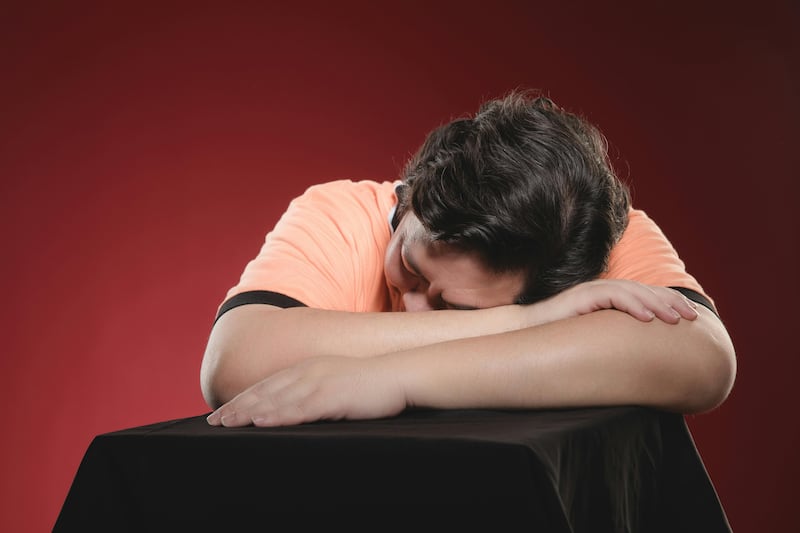 Hombre Descansando Sobre Una Mesa Sobre Un Fondo Rojo