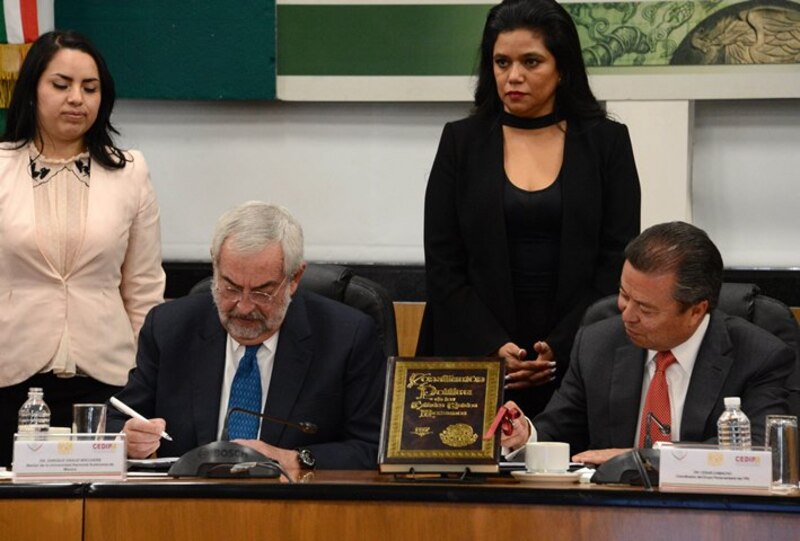 El presidente de México, Enrique Peña Nieto, firma el libro de visitantes distinguidos de la Cámara de Diputados.