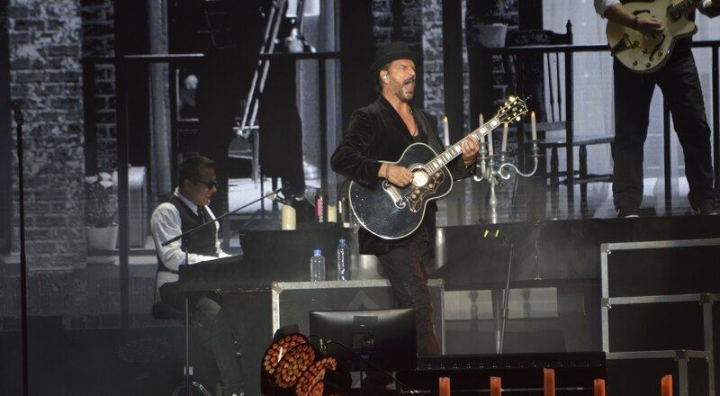 Un músico tocando la guitarra en un concierto.